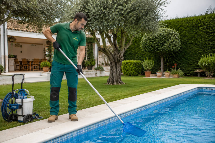 Um jardineiro faz a manutenção de uma piscina em Portimão